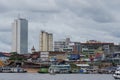 River view of the busy port of Manaus with a lot of ferries and boats. and some skyscrapers visible in the background. Location: