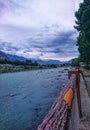 River view in mountain area. Woods and trees at shore of river. Cloud on the sky