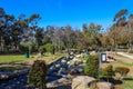 A river with water rushing over the rocks in the park surrounded by autumn trees and lush green grass with blue sky Royalty Free Stock Photo