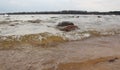 River wave on a sandy shore with two stones Royalty Free Stock Photo