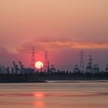 Riverbank with silhouettes of container terminal cranes during a sunset, Port of Antwerp, Belgium Royalty Free Stock Photo