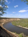 Riverbend in deep spring forestm with green trees on the bank of the river and sands under blue sky Royalty Free Stock Photo