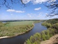 Riverbend in deep spring forestm with green trees on the bank of the river and sands under blue sky Royalty Free Stock Photo