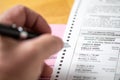 Riverside, California, USA - 10/2020: Man Holding Pen Over Blank Official Ballot with Envelope On Table in the 2020 Presidential