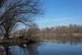 The riverside of the forest in early spring, the reflection of trees in the water.