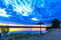 Riverside with magical dawn of the early morning with golden reflections in the water and the contour of an old wooden canopy Royalty Free Stock Photo