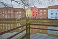 The riverside river Wensum with reflections of colorful houses and the tower and spire of the Cathedral