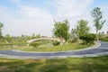 Riverside sinuous path to arch bridge in sunny spring morning