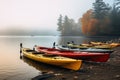 riverside view of colorful kayaks on the shore of a misty lake Royalty Free Stock Photo