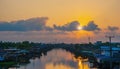 Riverside village with sunset sky and dark clouds, Reflection on the water surface, The sun is shaped like a heart,Bangkok, Royalty Free Stock Photo