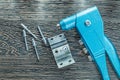 Riveting pliers rivets screws on wooden board Royalty Free Stock Photo