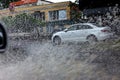 Ãâriving car on flooded road during flood caused by torrential rains. Cars float on water, flooding streets. Splash on car. Royalty Free Stock Photo