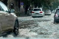 Ãâriving car on flooded road during flood caused by torrential rains. Cars float on water, flooding streets. Splash on car. Royalty Free Stock Photo