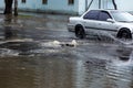 Ãâriving car on flooded road during flood caused by torrential rains. Cars float on water, flooding streets. Splash on car.