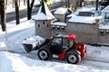 RIVNE, UKRAINE - FABRUARY 16, 2021. Removing snow from the streets with a tractor. A bulldozer with a bucket clears snow from the