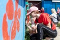 RIVNE, UKRAINE - JUNE 19, 2022. Girls painting doghouses. Dog kennels at a homeless dog shelter