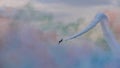 Aerobatic plane with white trail in the sky still full of colorful smoke Royalty Free Stock Photo