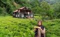 Rize / Turkey - August 06 2019: Tourist Turkish woman eats boiled corn and wooden house with tea field just near  Senyuva Cinciva Royalty Free Stock Photo