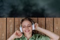 Rlaxed woman wearing headphones listening to music lying on a pier by natureal lake in summer Royalty Free Stock Photo