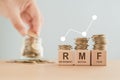 RMF abbreviation of Retirement Mutual Fund, RMF word on wooden cube block and stack of coin with blurred arranging coins, Save