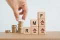 RMF ,Retirement Mutual Fund, RMF word with increasing percent on stack of wooden cube block with blurred arranging coins, Save