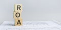 roa - return on assets acronym, wooden blocks, business concept, gray background