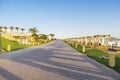 Road along lots of wooden furniture for rest, deck chair bed, gazebo on sand beach with curtains, tropical sea luxury resort. Royalty Free Stock Photo