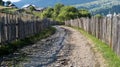 Road with ballast in the mountains with houses  - fence in the mountains Royalty Free Stock Photo