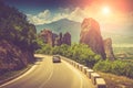 Road bend and a mountain range near Kalambaka. View of the Holy Monastery of Rousanou. Meteora monasteries. Greece. Europe. UNESCO Royalty Free Stock Photo