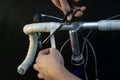 Road bike handlebars and dual control lever on a black background. Install handlebar tape white. Bicycle repair in a modern