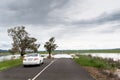 Road blocked by deep floodwater runoff from a field car unable to pass Royalty Free Stock Photo