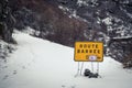 Road blocked sign on snow covered mountain road in Corsica
