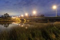 A road bridge over a river in the countryside, seen at night