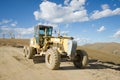 Road building machine with highland landscape Royalty Free Stock Photo