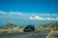 Road and car over hilly landscape covered by rocks