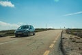 Road with car passing through rocky landscape