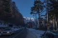 Road with cars in small city on background of snowy mountains. Romania, Sinaia