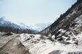 Road among the Caucasus mountains in winter, peaks and slopes are covered with snow on a Sunny day Royalty Free Stock Photo