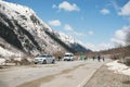 Road in the Caucasus mountains in winter, snow on the slopes, tourists, cars, people Royalty Free Stock Photo