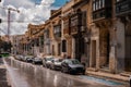 Road in the city of Valletta packed with cars and other traffic. Typical street in the mediterranean island of Malta on a rainy