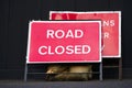 Road closed red sign and sand bags due to flood and surface water danger Royalty Free Stock Photo