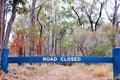 Road closed sign blocking vehicles on gravel dirt of bush forest Royalty Free Stock Photo