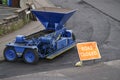 Road closed sign and repair to tar asphalt street with blue machine Royalty Free Stock Photo