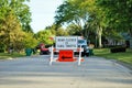 Road closed to thru traffic detour construction sign in a residential neighborhood