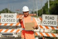 Road closed. Road worker outdoor. Builder in a hard hat working on a construction project at a site. A builder worker in Royalty Free Stock Photo
