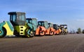 Road construction and asphalt compaction with yellow road rollers. Parking lot of road rollers in a row