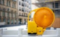 Road construction concept. Orange reflector caution light. Blur city background, space Royalty Free Stock Photo