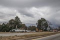 Road construction crew work with storm clouds