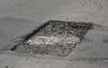 Road construction or driveway pothole repair: repairing an asphalt road with pothole method by cleaning and reshaping the pothole Royalty Free Stock Photo