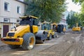 Road construction equipment: excavators, asphalt rollers, bulldozers on a city street with the road surface removed